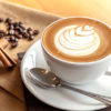 Cup of cafe' latte with coffee beans and cinnamon sticks BEST-ESPRESSO CAPPUCCINO